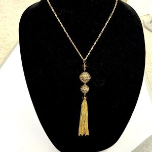 Long gold tone necklace with tassel